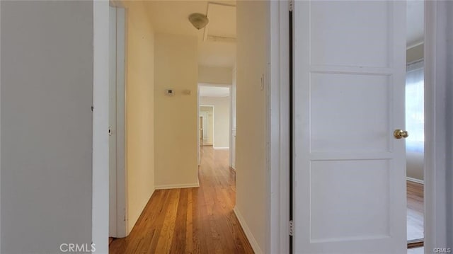 hallway with light hardwood / wood-style floors