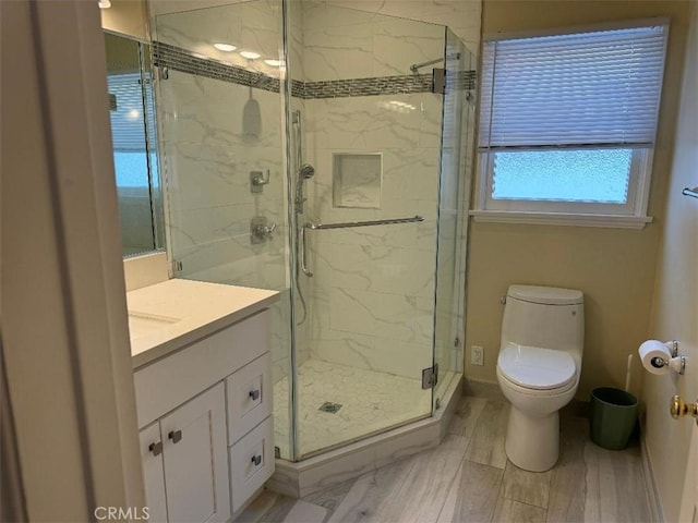 bathroom with vanity, toilet, and a shower with door