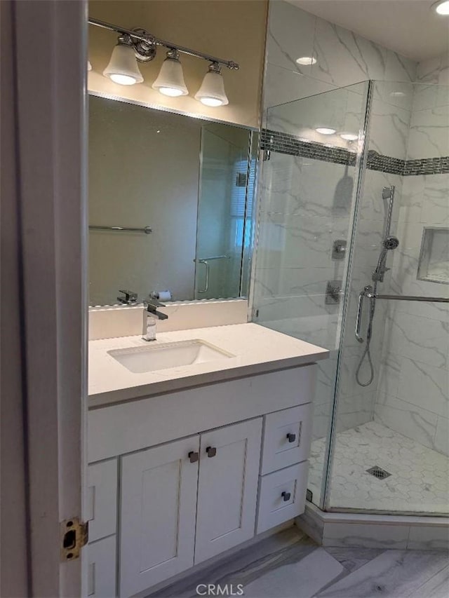 bathroom with vanity and a shower with door