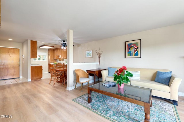 living room with light hardwood / wood-style flooring and ceiling fan