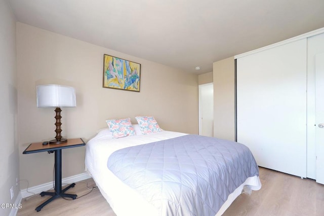 bedroom with light hardwood / wood-style flooring and a closet