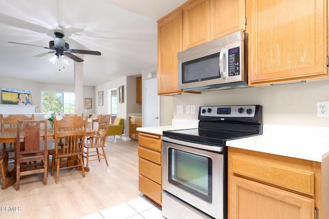 kitchen with ceiling fan, light hardwood / wood-style flooring, stainless steel appliances, and light brown cabinets