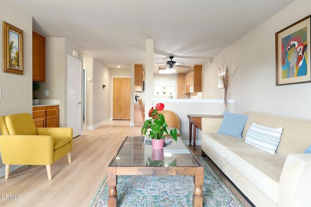 living room with ceiling fan and light hardwood / wood-style flooring