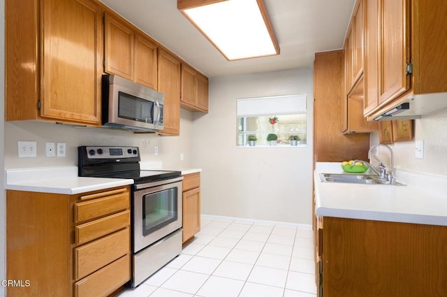 kitchen featuring light tile patterned floors, stainless steel appliances, and sink