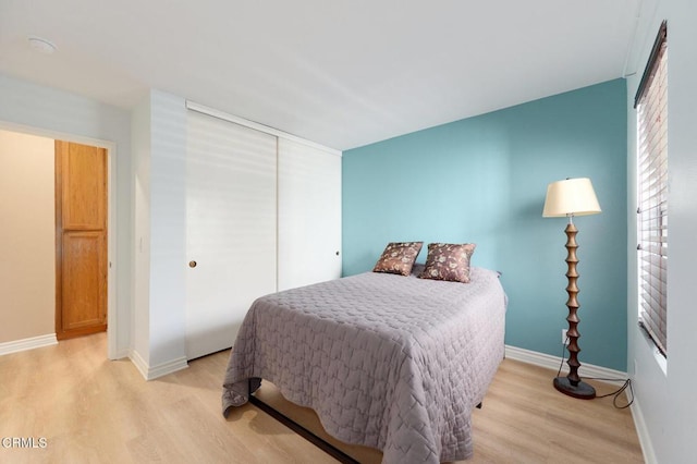 bedroom with light wood-type flooring and a closet