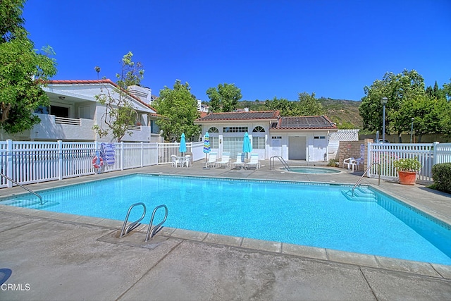 view of swimming pool with a community hot tub and a patio