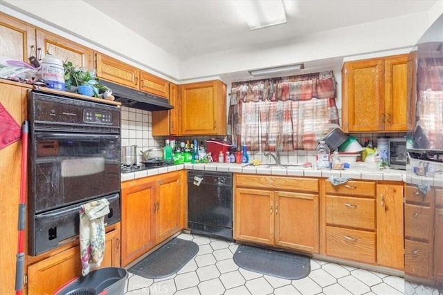 kitchen featuring decorative backsplash, tile counters, and black appliances