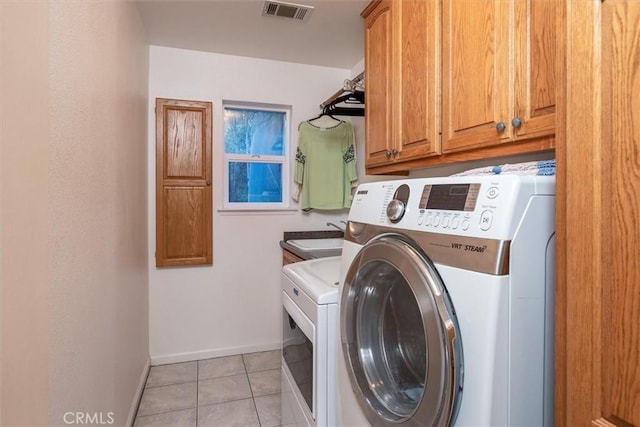 laundry room featuring washing machine and dryer, sink, light tile patterned flooring, and cabinets