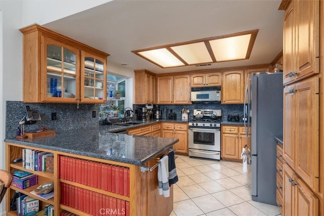 kitchen featuring kitchen peninsula, tasteful backsplash, stainless steel appliances, sink, and light tile patterned floors