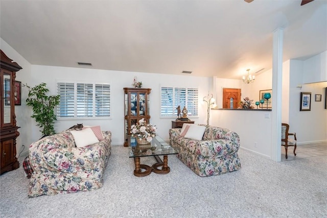 carpeted living room with a chandelier