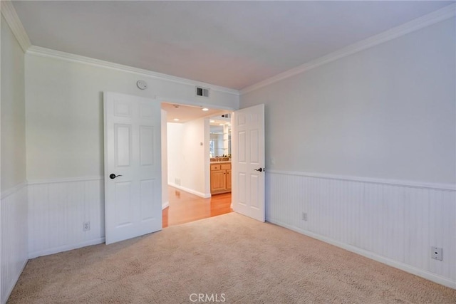 carpeted spare room featuring crown molding