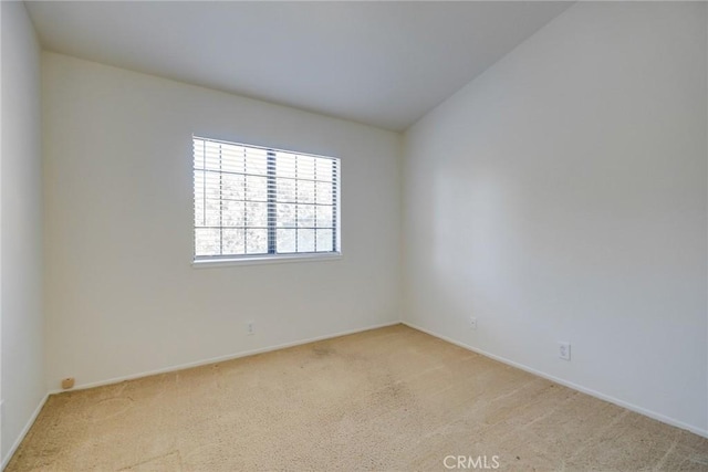 empty room featuring light carpet and vaulted ceiling