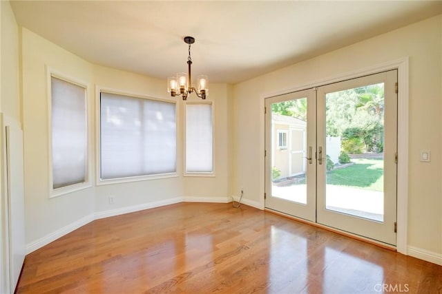 doorway featuring french doors, light hardwood / wood-style floors, and a notable chandelier