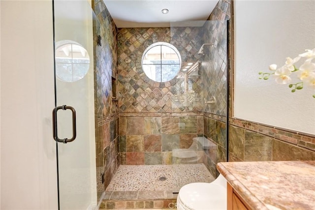 bathroom featuring tile walls, vanity, an enclosed shower, and toilet