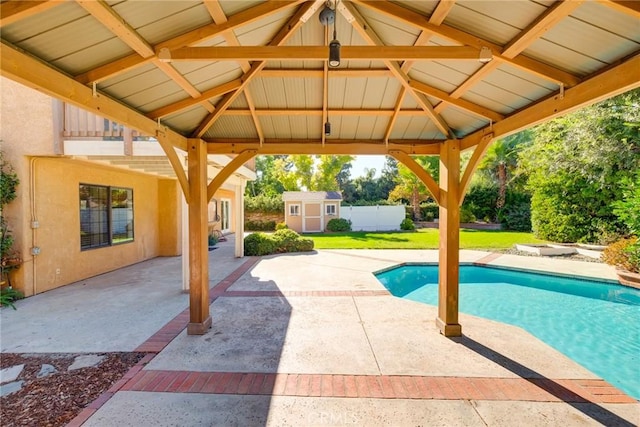 view of swimming pool featuring a gazebo, a patio, a storage shed, and a lawn