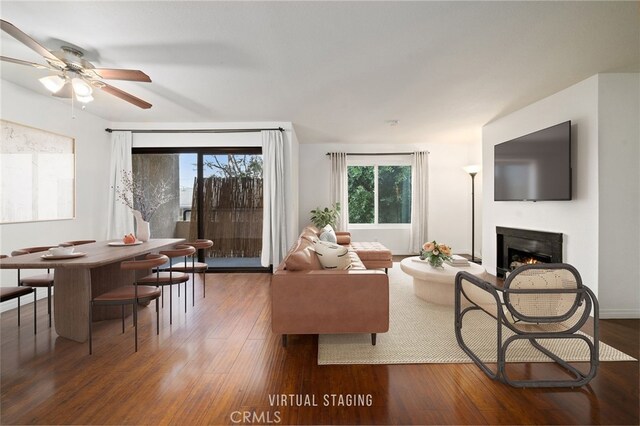 living room featuring ceiling fan and dark hardwood / wood-style flooring