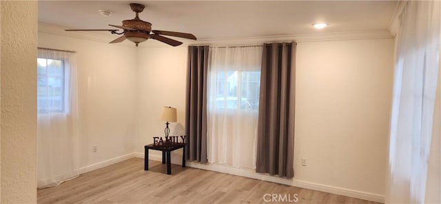 spare room with light hardwood / wood-style floors, plenty of natural light, ornamental molding, and ceiling fan