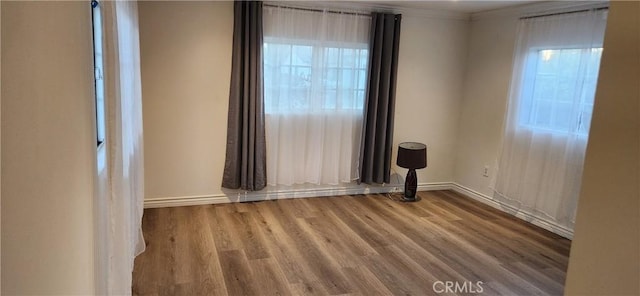 unfurnished room with hardwood / wood-style floors and crown molding