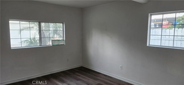 empty room featuring dark hardwood / wood-style flooring and a wealth of natural light