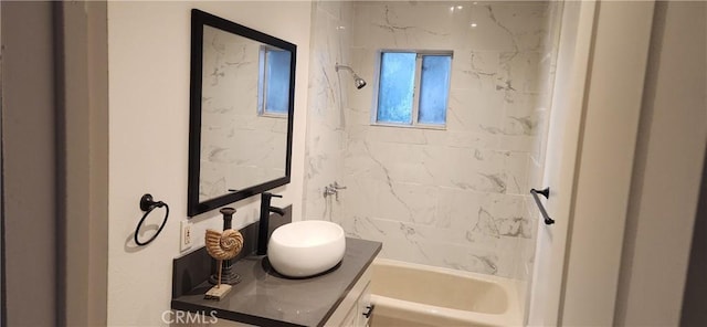 bathroom with tiled shower / bath combo and vanity