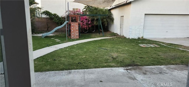 view of yard featuring a playground and a garage