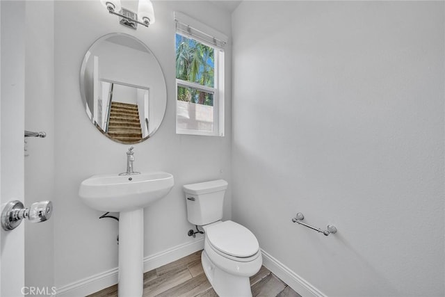 bathroom with hardwood / wood-style floors and toilet