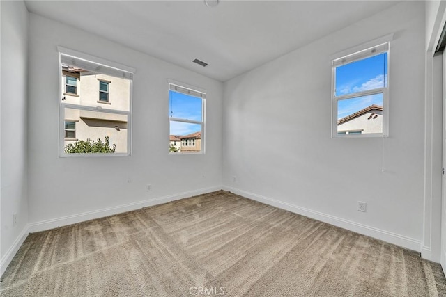 unfurnished room featuring carpet floors and a wealth of natural light