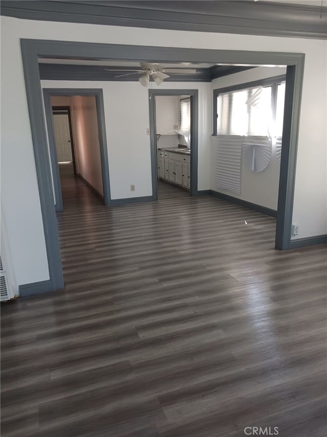 empty room with ceiling fan, dark hardwood / wood-style flooring, and ornamental molding