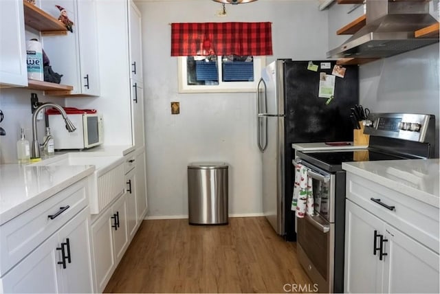 kitchen with white cabinetry, electric range, wood-type flooring, and wall chimney range hood