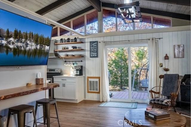 doorway featuring lofted ceiling with beams, wood walls, wooden ceiling, and light hardwood / wood-style flooring