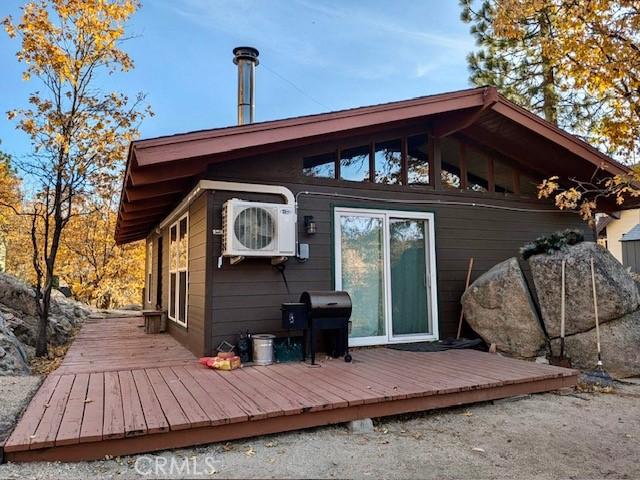 back of property featuring ac unit and a wooden deck