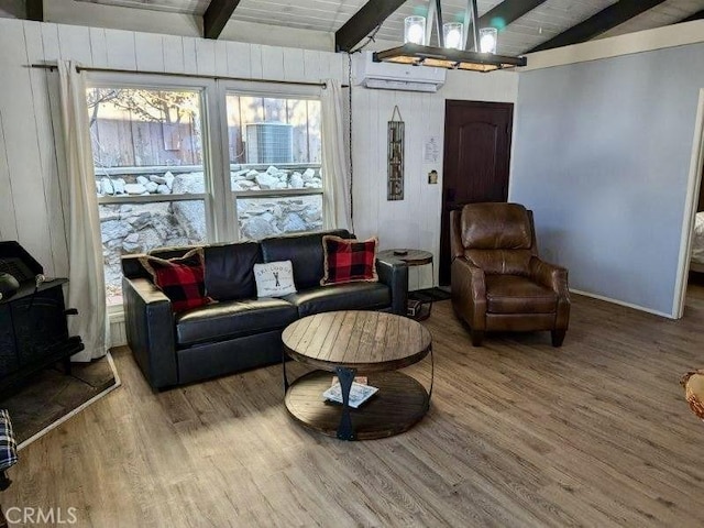 living room featuring hardwood / wood-style floors, a wood stove, lofted ceiling with beams, a wall mounted AC, and wood ceiling