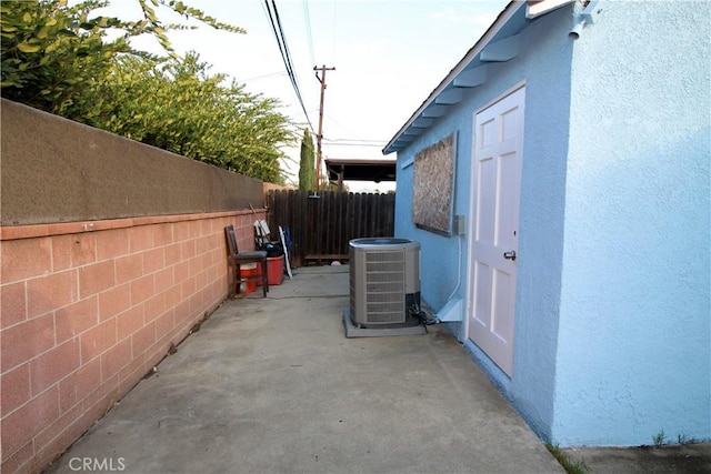 view of side of home with cooling unit and a patio