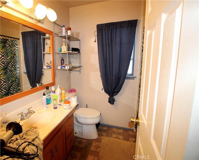 bathroom featuring vanity, walk in shower, and toilet