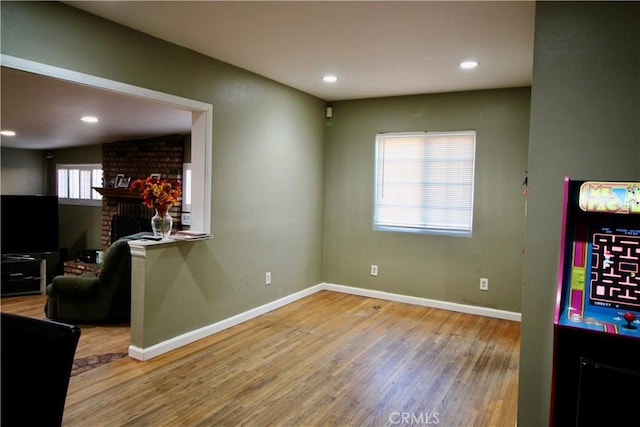 living room featuring a brick fireplace and hardwood / wood-style floors