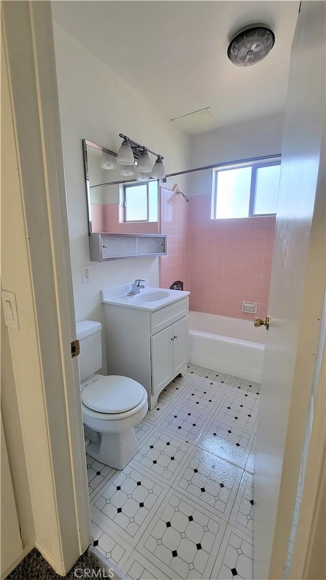 full bathroom featuring tile patterned flooring, vanity, toilet, and tiled shower / bath combo