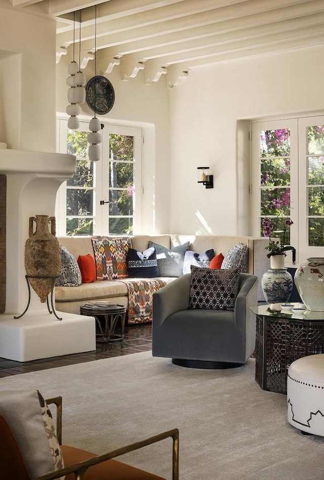 carpeted living room with french doors, a wealth of natural light, and beam ceiling