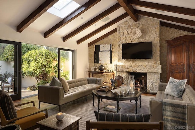 living room with beamed ceiling, a stone fireplace, wood-type flooring, and high vaulted ceiling