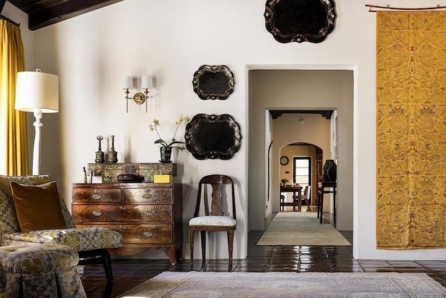 hallway with beamed ceiling and dark tile patterned flooring