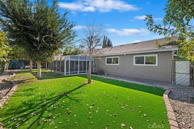 back of house featuring a lanai, central AC, and a yard