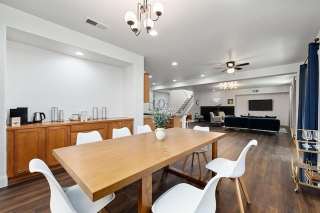 dining area with ceiling fan with notable chandelier and dark hardwood / wood-style floors