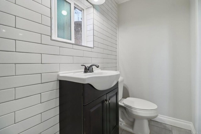 bathroom featuring tile patterned flooring, vanity, and toilet