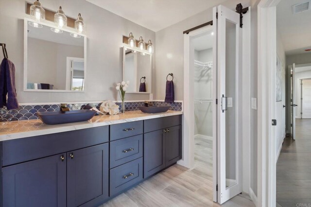 bathroom featuring hardwood / wood-style flooring, vanity, and decorative backsplash