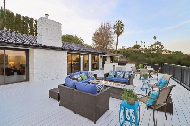 wooden deck featuring grilling area, exterior kitchen, and an outdoor hangout area