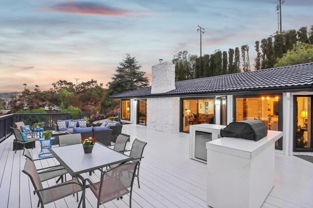 deck at dusk with an outdoor hangout area and a grill