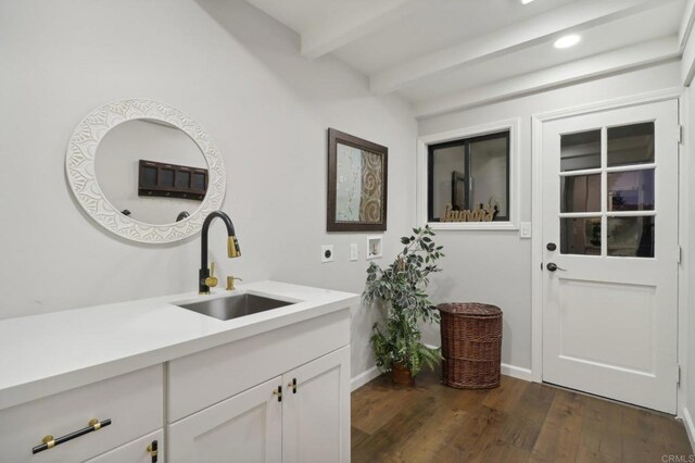 bathroom with beamed ceiling, wood-type flooring, and sink