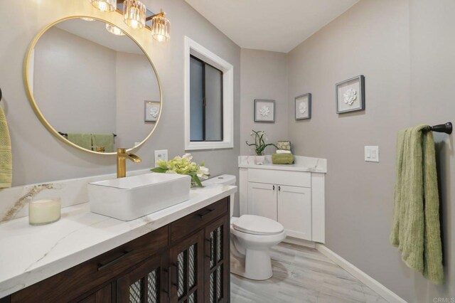 bathroom featuring hardwood / wood-style flooring, vanity, and toilet