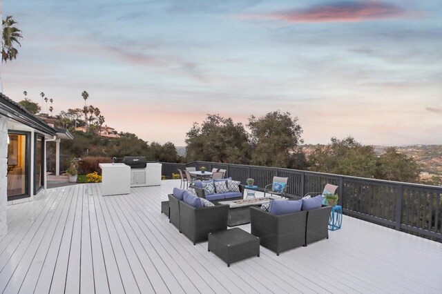 deck at dusk featuring area for grilling and an outdoor hangout area