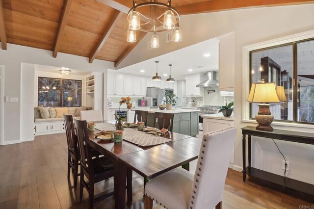 dining room featuring wood ceiling, lofted ceiling with beams, a notable chandelier, and wood-type flooring