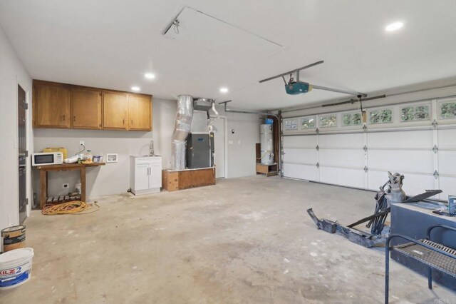 garage featuring heating unit, water heater, and a garage door opener